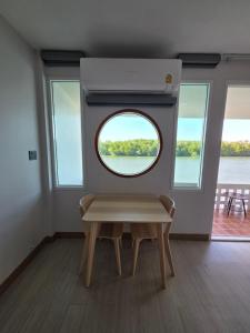 une pièce avec une fenêtre ronde et un banc dans l'établissement Madee House - มาดีเฮ้าส์, 