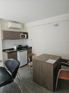 een keuken met een tafel en stoelen in een kamer bij Refugio Urbano Apartamentos in Campana