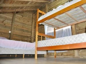 deux lits superposés dans une chambre avec plafond en bois dans l'établissement Pousada pantera do rosa, à Imbituba