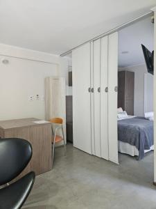 een slaapkamer met witte kasten, een bed en een bureau bij Refugio Urbano Apartamentos in Campana