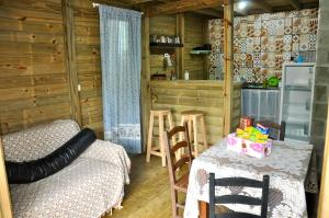 un salon avec un lit et une table et une cuisine dans l'établissement Pousada pantera do rosa, à Imbituba