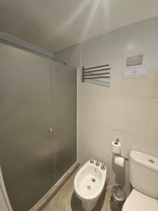 een kleine badkamer met toilet en douche bij Refugio Urbano Apartamentos in Campana +16 foto's