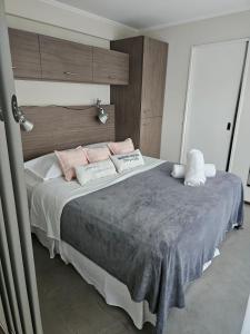 een slaapkamer met een groot bed met roze en witte kussens bij Refugio Urbano Apartamentos in Campana