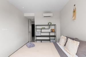 ein weißes Schlafzimmer mit einem Bett und einem Regal in der Unterkunft The Grand in Jan Thiel + 14 Fotos