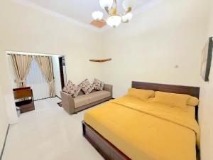 una camera con letto giallo e divano di HR Hotel Batu a Batu