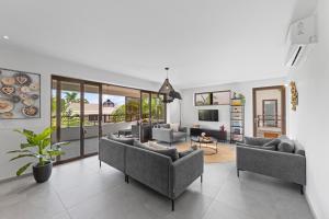 ein Wohnzimmer mit zwei Sofas und einem Fernseher in der Unterkunft The Grand in Jan Thiel