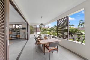 ein Esszimmer mit einem Tisch und großen Fenstern in der Unterkunft The Grand in Jan Thiel