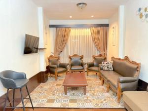a living room with a couch and chairs and a table at HR Hotel Batu in Batu