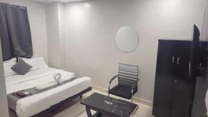 a small room with a bed and a chair at THE NEXOS UNIQUE SUITEs in Jāmb
