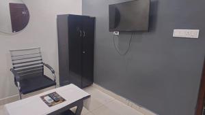 a room with a chair and a tv and a table at THE NEXOS UNIQUE SUITEs in Jāmb