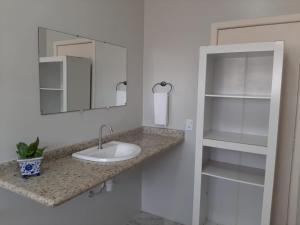 bagno con lavandino, specchio e scaffali di Pousada Tartaruga Marinha a Ubatuba Altre 95 foto
