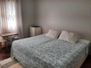 una camera da letto con un letto con un piumone blu e bianco di Pousada Tartaruga Marinha a Ubatuba