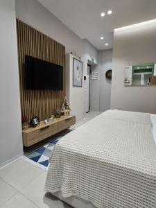 a bedroom with a bed and a flat screen tv at Elite Guesthouse in Tirana