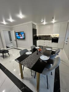 a dining room with a black table and chairs at Apartament modern in Căuşeni