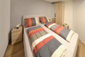 een slaapkamer met 2 bedden met kussens en een dressoir bij Wohnen bei Gerlis - DZ 105 in Burbach