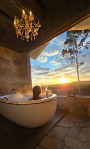 een vrouw in een bad in een kamer met een raam bij Pousada Villa Dolce Amore - Boutique Hotel in Campos do Jordão