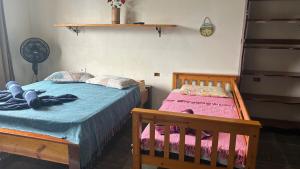 a bedroom with two twin beds and a fan at Casa da Barra in Ubatuba