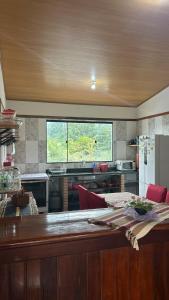 une cuisine avec une table et une grande fenêtre dans l'établissement Casa da Barra, à Ubatuba