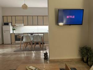a kitchen with a table and a tv on a wall at Little Florina Nest in Florina