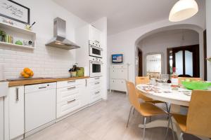 a kitchen with white cabinets and a table with chairs at Sunny Sopot in Sopot