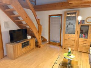 un soggiorno con TV a schermo piatto e scale in legno di Kuckucksnest a Ühlingen-Birkendorf
