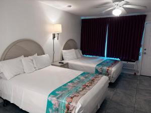 una camera d'albergo con due letti e un ventilatore a soffitto di Apollo Motel a Wildwood Crest Altre 61 foto