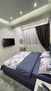 a bedroom with a bed and a flat screen tv at Kamoli Khujandi 166 in Khujand