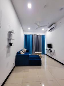 a living room with a blue couch and a table at Sea view Apartmen in Trizen in Colombo