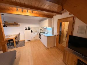 una cucina con mobili bianchi e pavimento in legno di Kuckucksnest a Ühlingen-Birkendorf