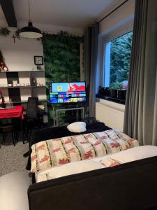 a bedroom with a bed and a television and a table at Apartament Pod Kukułką in Kłodzko