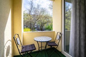 een balkon met een tafel en 2 stoelen en een raam bij Comfort 66 Large Family City Home in Miskolc +9 foto's