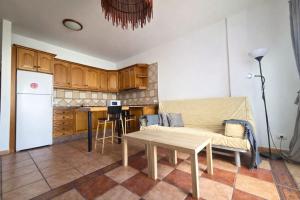 a living room with a couch and a table in a kitchen at Famara Chill House in Famara