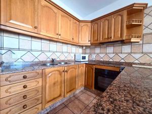 a kitchen with wooden cabinets and a sink at Famara Chill House in Famara +8 photos