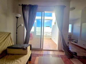a bedroom with a bed and a sliding glass door at Famara Chill House in Famara