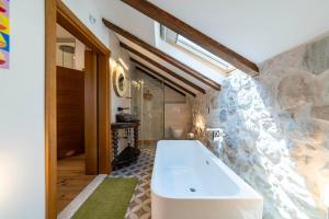 a bathroom with a large tub and a stone wall at Seafront Kotor Bay View Villa NW in Muo +27 photos