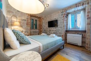 a bedroom with a bed in a brick wall at Seafront Kotor Bay View Villa NW in Muo