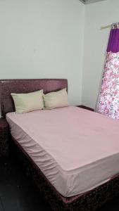 een bed met witte lakens en kussens in een kamer bij Diana hotel 2 in Encarnación