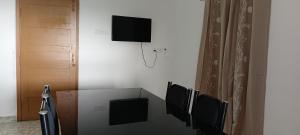 a room with three chairs and a tv on the wall at AI cube Homes in Pīrmed