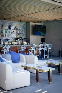 a living room with white couches and tables and a counter at Hotel Dublé in Navojoa