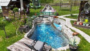 a small pool with a bench and a waterfall at Kraljica Radoinja in Kokin Brod