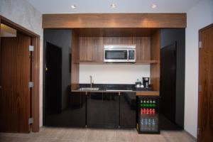 a kitchen with a sink and a microwave at Hotel Dublé in Navojoa