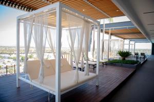 a porch with white curtains and chairs on a deck at Hotel Dublé in Navojoa