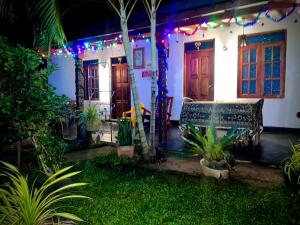 a house with christmas lights and a bench in the yard at Green Lake Sigiriya in Sigiriya