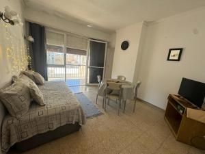 une chambre avec un lit, une table et des chaises dans l'établissement Departamento cerca de la playa a tres cuadras dela playa, à Mar del Plata