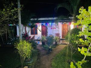 a house decorated with christmas lights at night at Green Lake Sigiriya in Sigiriya