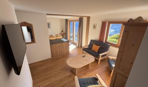 a small living room with a table and a couch at Hotel Garni Postigliun Andiast in Andest