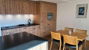 a kitchen and dining room with a table and chairs at Hotel Garni Postigliun Andiast in Andest