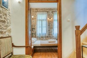 een kleine slaapkamer met een bed en een spiegel bij Medieval Villa Philoxenia in Kalamoti