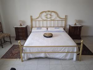 een bed met een witte sprei en een hoed erop bij appartamento Gabry in Dolianova