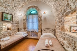 twee bedden in een kamer met een stenen muur bij Medieval Villa Philoxenia in Kalamoti